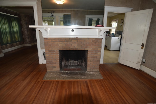 190 Victoria Rd, Hartford, CT 06114 - detailed view of wood finished floors, a brick fireplace, and washer / dryer