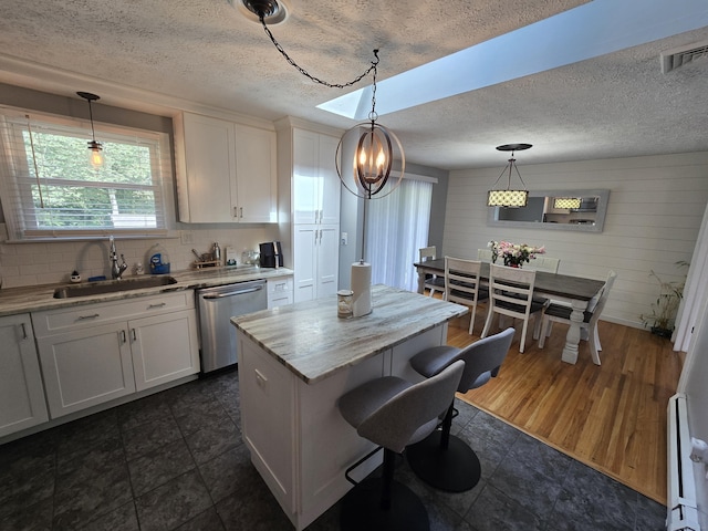 77 Hartz Ln, East Hartford, CT 06118 - kitchen featuring stainless steel dishwasher, white cabinetry, a textured ceiling, a center island, and decorative backsplash