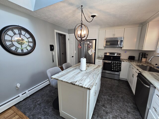 77 Hartz Ln, East Hartford, CT 06118 - kitchen with stainless steel appliances, a chandelier, baseboard heating, light stone counters, and white cabinets