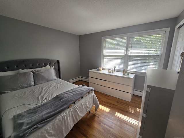 77 Hartz Ln, East Hartford, CT 06118 - bedroom with baseboard heating, wood finished floors, and a textured ceiling