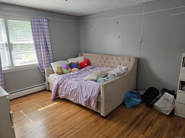 77 Hartz Ln, East Hartford, CT 06118 - bedroom featuring a baseboard radiator, light wood-style floors, multiple windows, and a textured ceiling