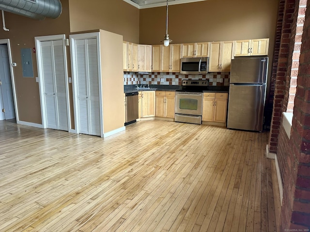 325 Lafayette St Unit 3303, Bridgeport, CT 06604 - kitchen with stainless steel appliances, light brown cabinetry, light wood-style floors, dark countertops, and backsplash