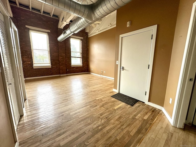 325 Lafayette St Unit 3303, Bridgeport, CT 06604 - unfurnished living room featuring brick wall and light wood-style floors