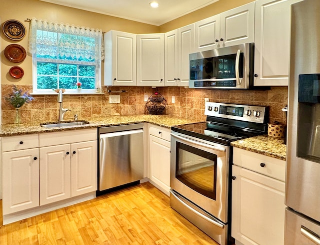 168 Cooper Ln, Hamden, CT 06514 - kitchen featuring stainless steel appliances, light wood-type flooring, white cabinetry, and decorative backsplash