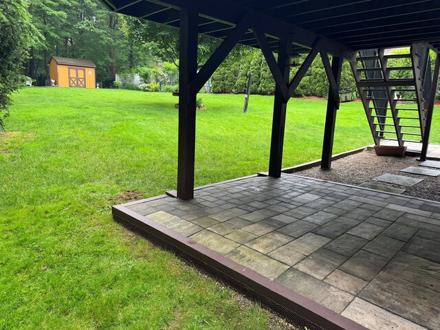 168 Cooper Ln, Hamden, CT 06514 - view of grassy yard with a storage unit, stairway, and a patio
