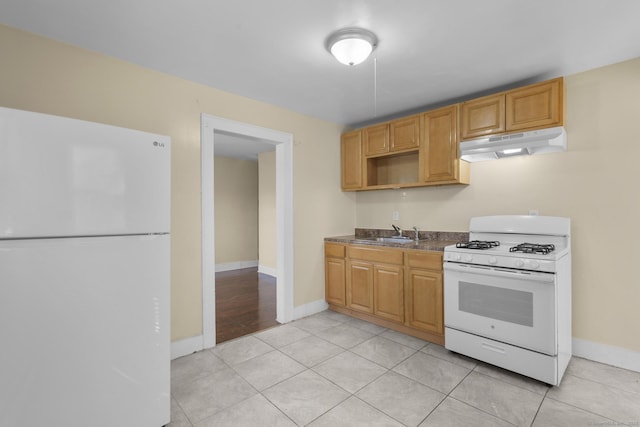 122 Derby Ave, New Haven, CT 06511 - kitchen with white appliances, under cabinet range hood, dark countertops, and light tile patterned flooring
