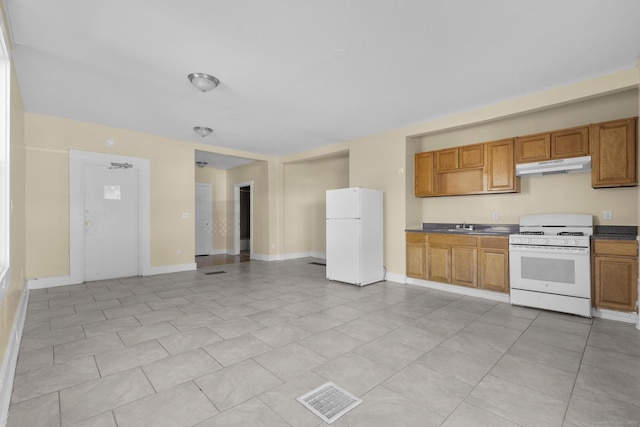 122 Derby Ave, New Haven, CT 06511 - kitchen with white appliances, under cabinet range hood, brown cabinets, and light tile patterned flooring