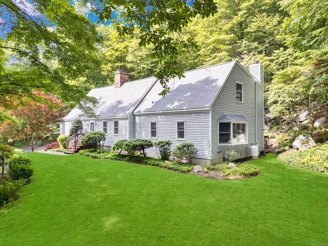431 Fan Hill Rd, Monroe, CT 06468 - rear view of house with a chimney, a lawn, and a shingled roof