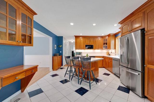 431 Fan Hill Rd, Monroe, CT 06468 - kitchen featuring appliances with stainless steel finishes, a center island, a breakfast bar area, glass insert cabinets, and backsplash