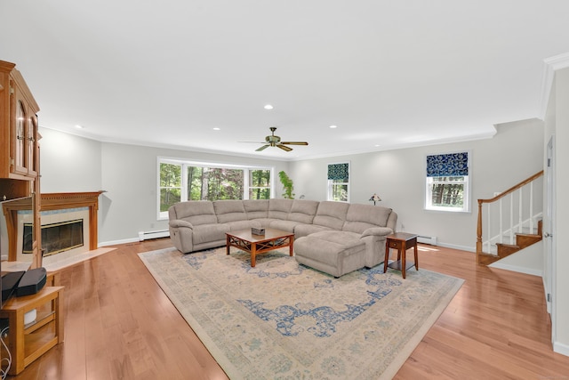 431 Fan Hill Rd, Monroe, CT 06468 - living room with a baseboard radiator, light wood-style floors, crown molding, ceiling fan, and stairs
