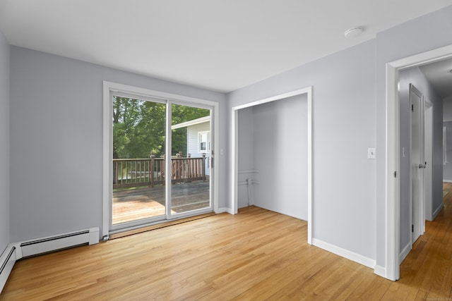 538 Quaddick Rd, Thompson, CT 06277 - unfurnished bedroom with access to exterior, light wood finished floors, and a baseboard radiator