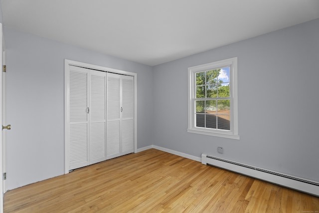 538 Quaddick Rd, Thompson, CT 06277 - unfurnished bedroom featuring a baseboard radiator, light wood-style flooring, and a closet