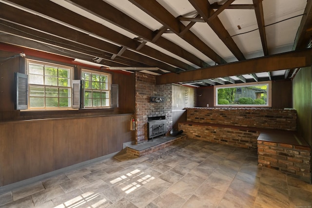 538 Quaddick Rd, Thompson, CT 06277 - unfurnished living room featuring wood walls, brick wall, and stone finish floors