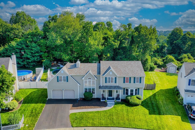 56 Stagecoach Cir, Milford, CT 06460 - view of front facade with driveway, a chimney, a porch, and roof with shingles