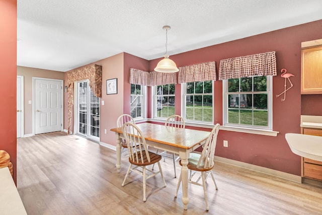 56 Stagecoach Cir, Milford, CT 06460 - dining room with healthy amount of natural light, light wood-style floors, and a textured ceiling