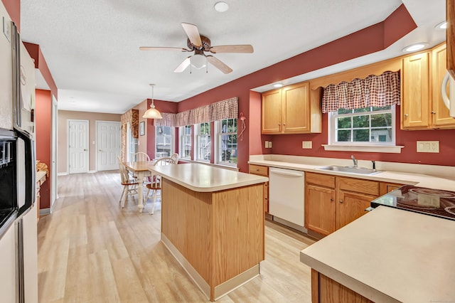 56 Stagecoach Cir, Milford, CT 06460 - kitchen with white dishwasher, light wood-style floors, light countertops, a center island, and a ceiling fan