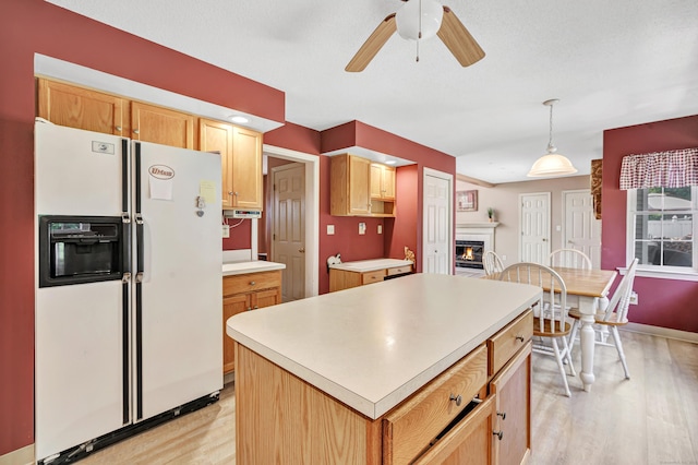 56 Stagecoach Cir, Milford, CT 06460 - kitchen with white refrigerator with ice dispenser, light wood finished floors, a ceiling fan, a center island, and light countertops