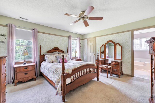 56 Stagecoach Cir, Milford, CT 06460 - bedroom featuring light carpet, multiple windows, ceiling fan, a textured ceiling, and connected bathroom