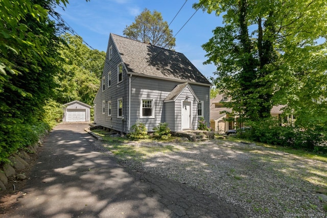 141 Cannon St, Hamden, CT 06518 - view of front of property with a shingled roof, a detached garage, an outdoor structure, and asphalt driveway