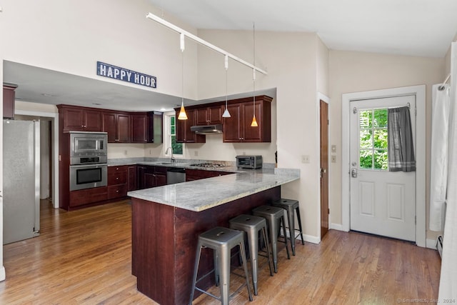141 Cannon St, Hamden, CT 06518 - kitchen with stainless steel appliances, a peninsula, high vaulted ceiling, light wood finished floors, and a kitchen breakfast bar