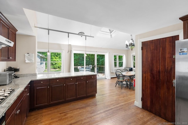 141 Cannon St, Hamden, CT 06518 - kitchen with light wood finished floors, freestanding refrigerator, a chandelier, dark brown cabinetry, and pendant lighting