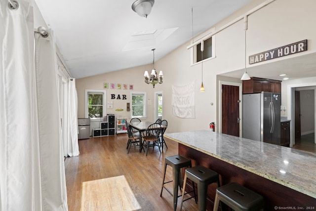 141 Cannon St, Hamden, CT 06518 - kitchen featuring freestanding refrigerator, a skylight, a kitchen bar, wood finished floors, and a chandelier
