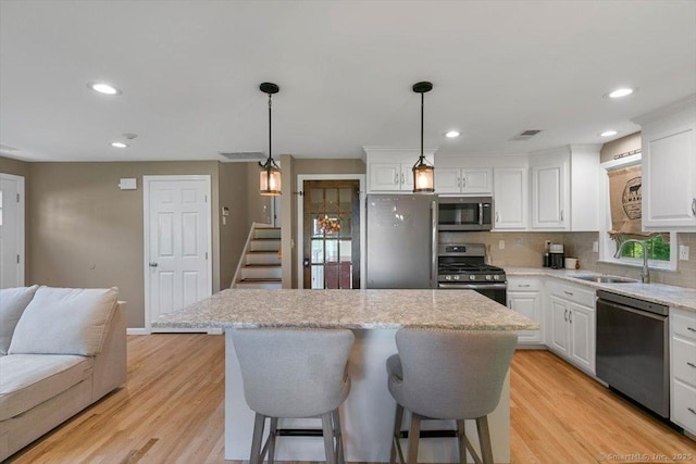 2 Sunwoods Cir, Hamden, CT 06518 - kitchen with stainless steel appliances, a center island, white cabinetry, backsplash, and recessed lighting