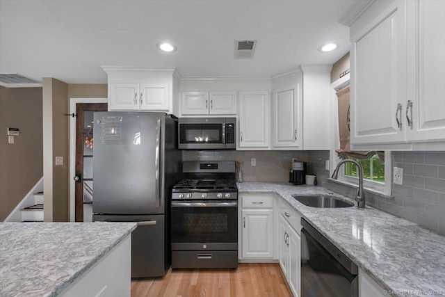 2 Sunwoods Cir, Hamden, CT 06518 - kitchen featuring appliances with stainless steel finishes, white cabinets, backsplash, light wood-style floors, and recessed lighting