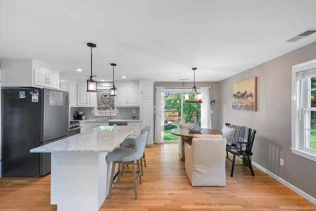 2 Sunwoods Cir, Hamden, CT 06518 - kitchen featuring freestanding refrigerator, white cabinetry, light wood-style floors, a center island, and recessed lighting