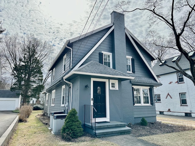 111 Spring Garden St, Hamden, CT 06517 - view of front facade with a chimney, a shingled roof, and an outbuilding