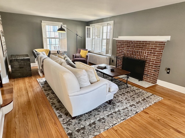 111 Spring Garden St, Hamden, CT 06517 - living room with radiator, wood finished floors, and a brick fireplace
