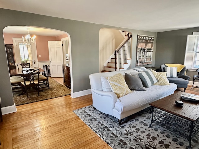 111 Spring Garden St, Hamden, CT 06517 - living area featuring arched walkways, light wood-type flooring, stairway, and a chandelier