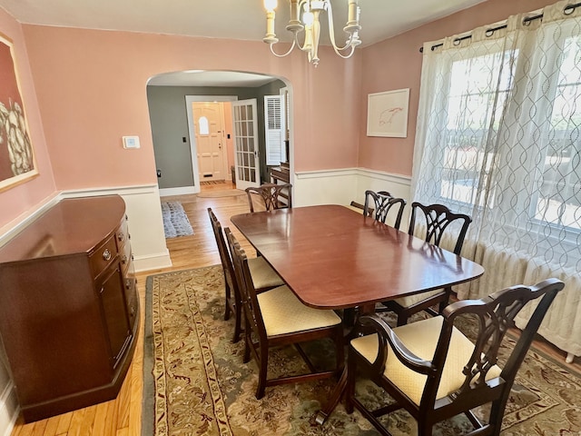 111 Spring Garden St, Hamden, CT 06517 - dining area with arched walkways, a wainscoted wall, and light wood-type flooring