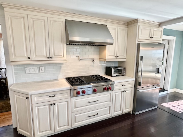 111 Spring Garden St, Hamden, CT 06517 - kitchen featuring wall chimney range hood, appliances with stainless steel finishes, dark wood-style floors, light countertops, and decorative backsplash