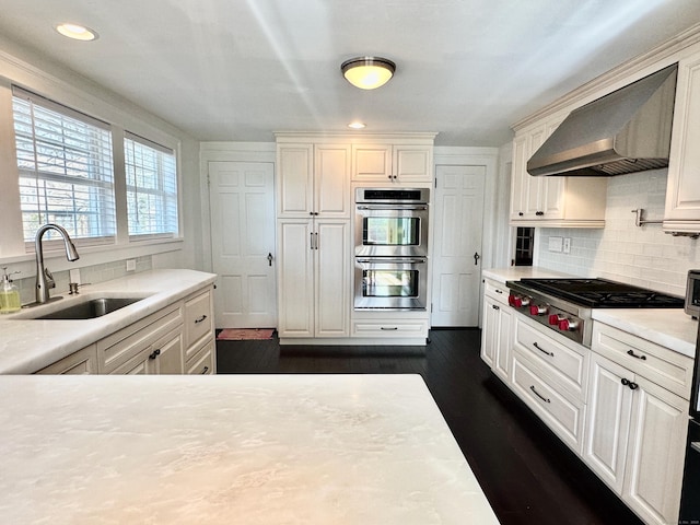 111 Spring Garden St, Hamden, CT 06517 - kitchen featuring wall chimney exhaust hood, appliances with stainless steel finishes, light countertops, tasteful backsplash, and white cabinetry