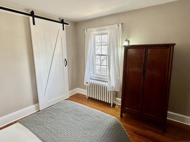 111 Spring Garden St, Hamden, CT 06517 - bedroom with radiator, a barn door, and wood finished floors