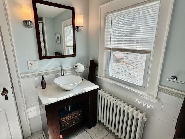 111 Spring Garden St, Hamden, CT 06517 - bathroom with radiator, tile walls, marble look tiles, a wainscoted wall, and vanity