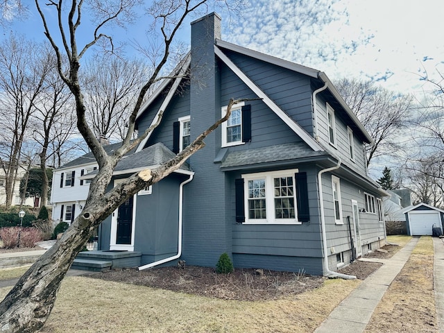 111 Spring Garden St, Hamden, CT 06517 - view of property exterior featuring a chimney, driveway, an outbuilding, a garage, and a shingled roof