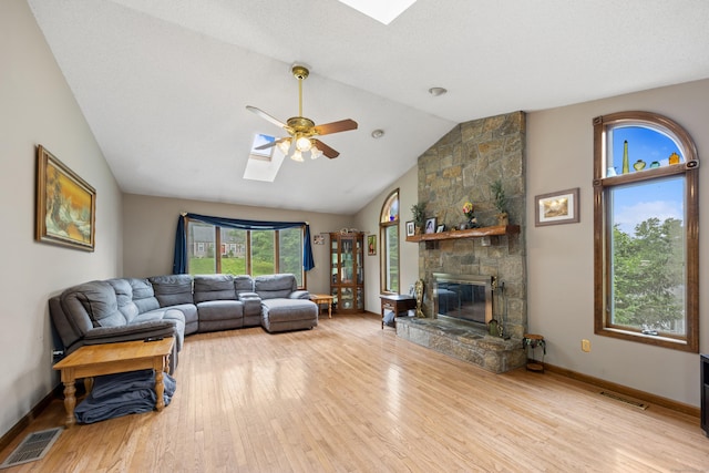 291 Guinevere Rdg, Cheshire, CT 06410 - living area featuring a skylight, ceiling fan, wood finished floors, a stone fireplace, and high vaulted ceiling