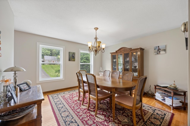 291 Guinevere Rdg, Cheshire, CT 06410 - dining room with a chandelier, light wood-type flooring, and a textured ceiling