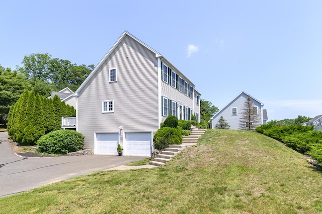 7 Castlewood Dr Unit 7, Monroe, CT 06468 - view of side of home featuring stairway, an attached garage, asphalt driveway, and a lawn