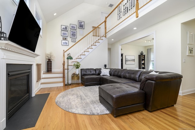 7 Castlewood Dr Unit 7, Monroe, CT 06468 - living room featuring high vaulted ceiling, stairs, wood finished floors, and a fireplace with flush hearth