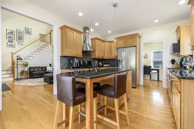 7 Castlewood Dr Unit 7, Monroe, CT 06468 - kitchen with stove, wall chimney exhaust hood, stainless steel refrigerator with ice dispenser, a kitchen bar, and light wood finished floors