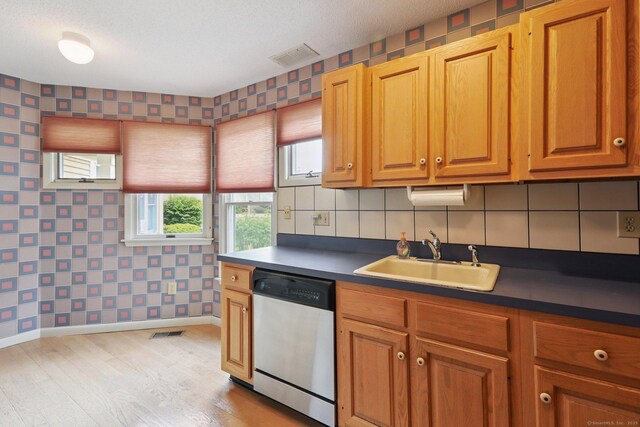 17 Brittania Dr Unit 17, Danbury, CT 06811 - kitchen featuring stainless steel dishwasher, wallpapered walls, light wood-style floors, dark countertops, and brown cabinets