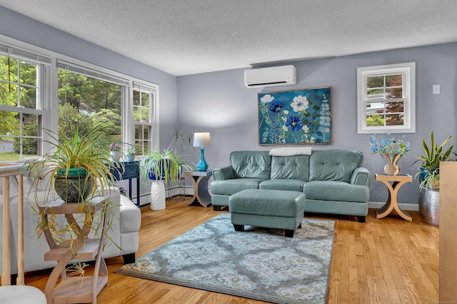 81 Charter Oak Dr, East Lyme, CT 06333 - living area featuring a wall mounted air conditioner, a textured ceiling, wood finished floors, and baseboard heating