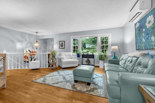 81 Charter Oak Dr, East Lyme, CT 06333 - living area with an AC wall unit, a textured ceiling, wood finished floors, a baseboard radiator, and a chandelier