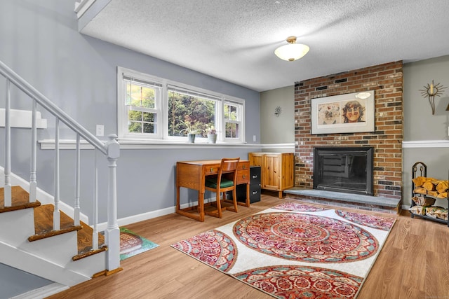 81 Charter Oak Dr, East Lyme, CT 06333 - office space featuring wood finished floors, a textured ceiling, and a fireplace
