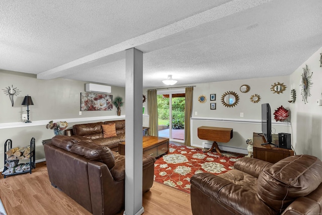 81 Charter Oak Dr, East Lyme, CT 06333 - living area with a wall mounted AC, a baseboard heating unit, light wood finished floors, and a textured ceiling
