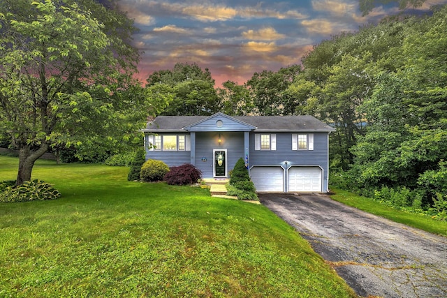 81 Charter Oak Dr, East Lyme, CT 06333 - raised ranch featuring asphalt driveway, a garage, a yard, and view of scattered trees