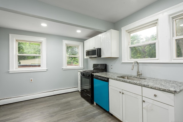 49 Olmsted St, East Hartford, CT 06108 - kitchen with stainless steel microwave, dishwasher, black gas range oven, a baseboard radiator, and white cabinetry